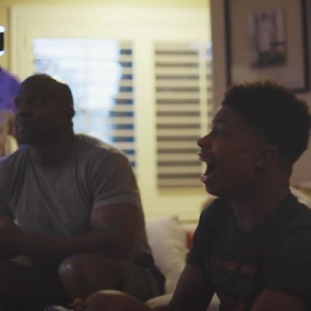 Terry Crews and Isaiah Crews are sitting next to each other in a couch.